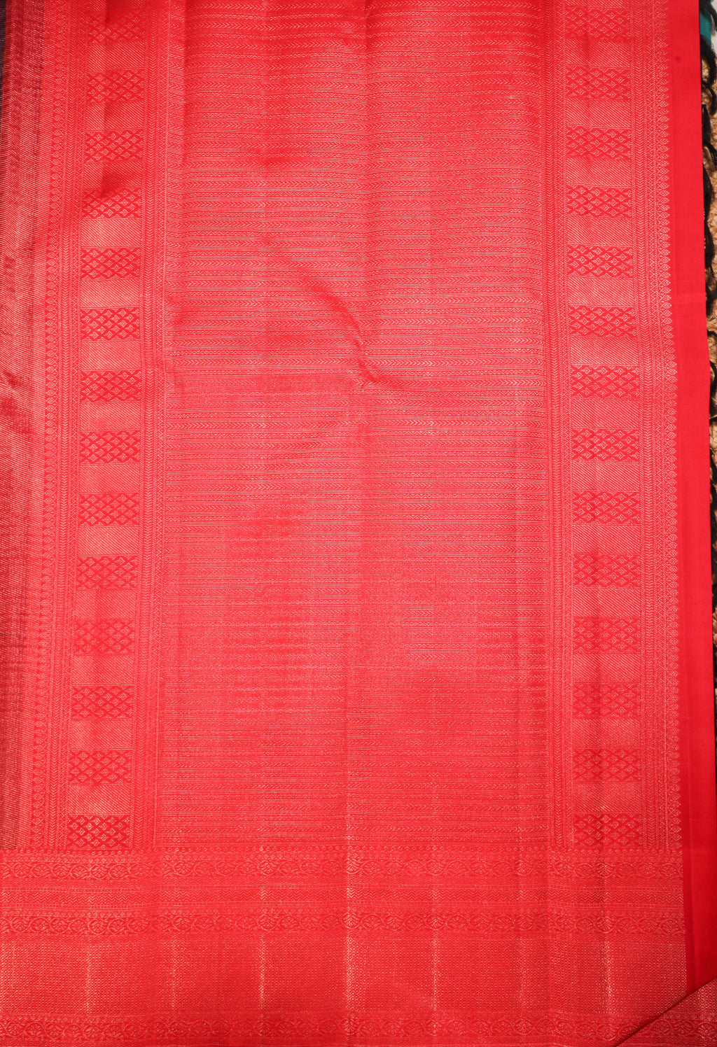 Vibrant red Kanchipuram silk saree with intricate zari patterns and traditional borders