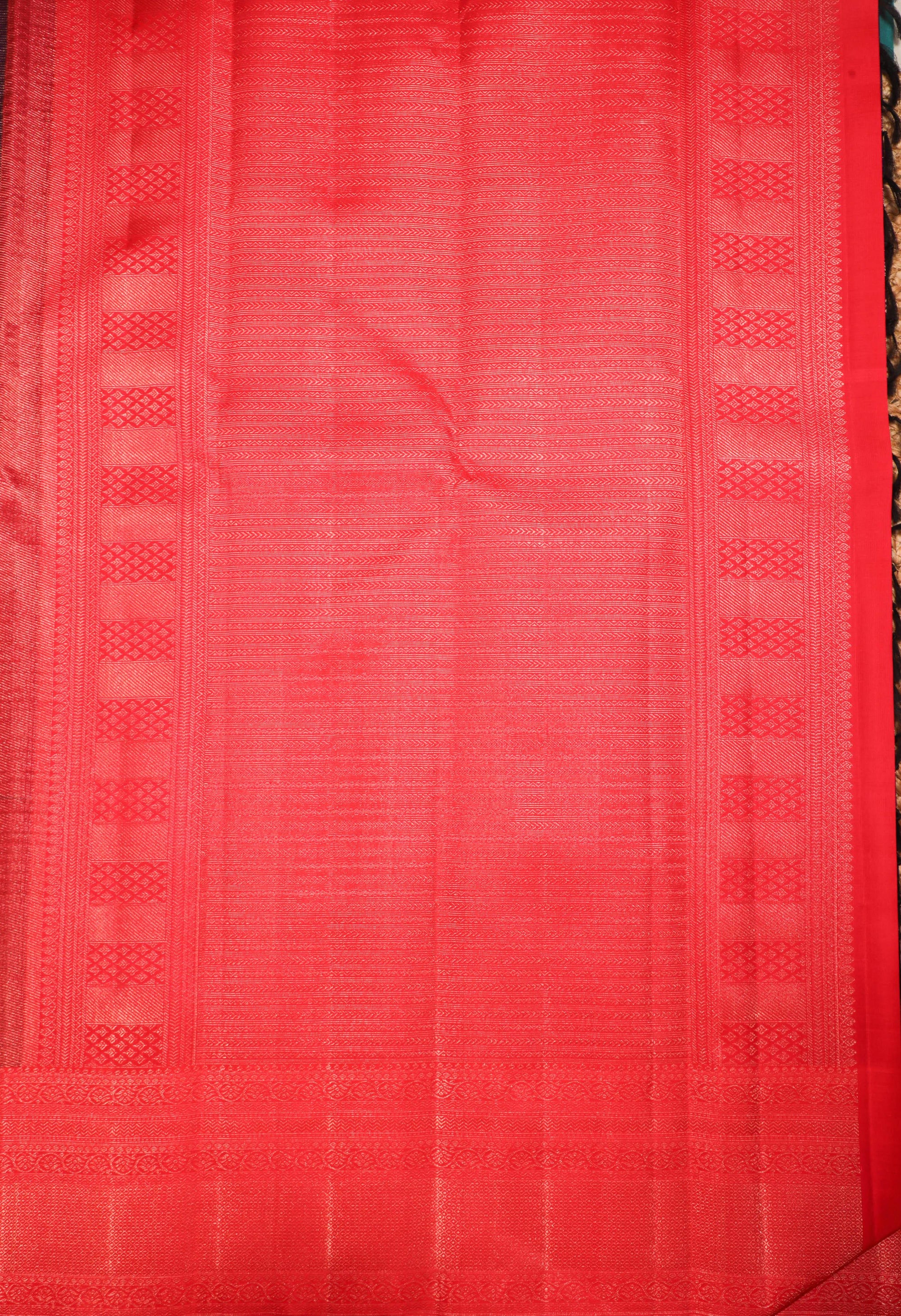 Vibrant red Kanchipuram silk saree with intricate zari patterns and traditional borders